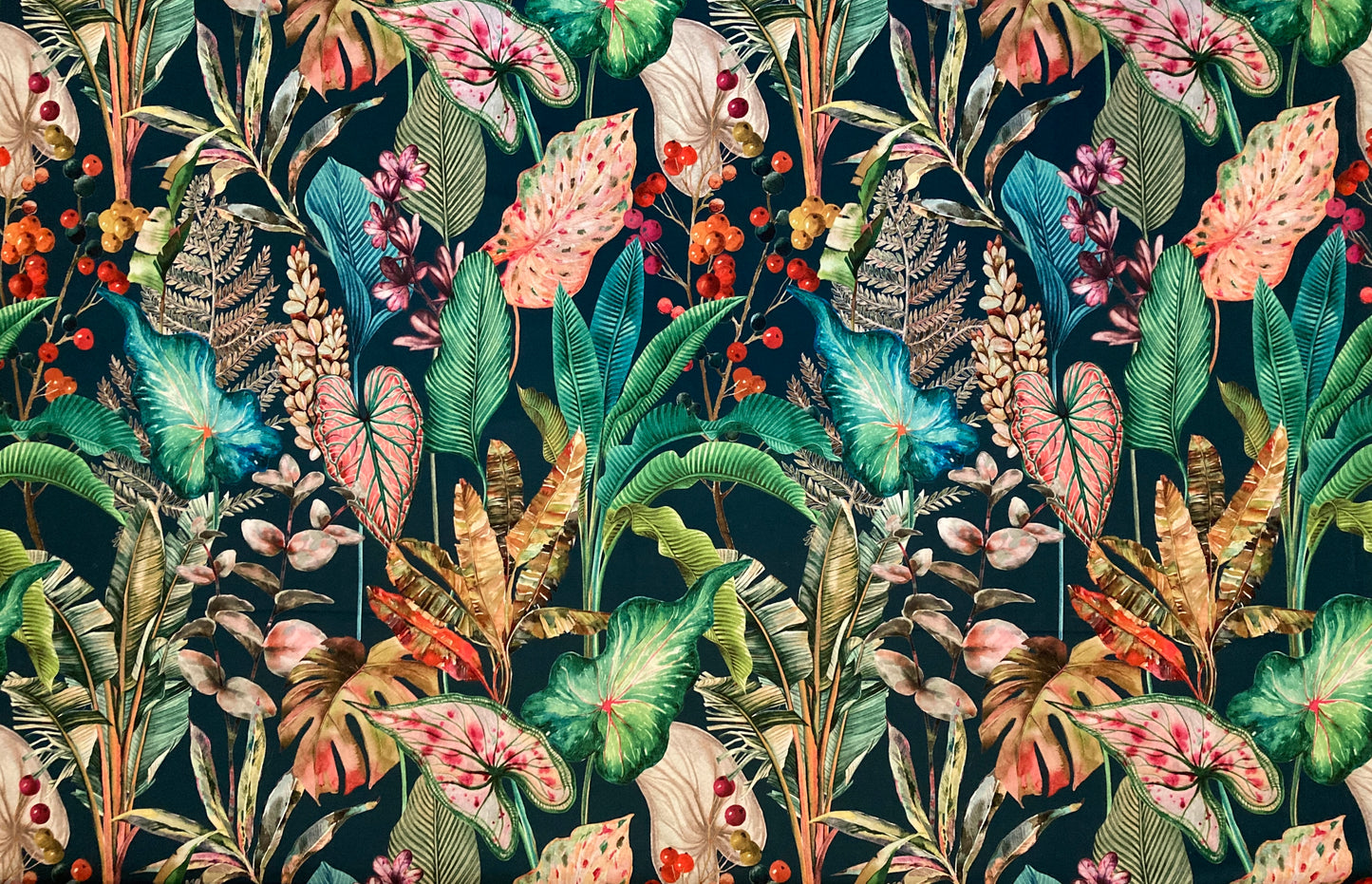A dense tropical botanical pattern featuring a variety of leaves, flowers, and berries in shades of green, pink, blue, and orange on a dark teal background. Pattern repeat: 68cm / 26.7inch